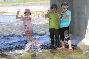 川に入り、ポーズをとる子どもたち