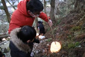 男の子とお父さんが二人で火を灯している写真