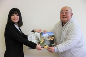 木曽義仲信州丸子会会長と学生がパンフレットを持っている写真