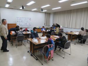ぬりえをする人達を会場後方から撮影した写真