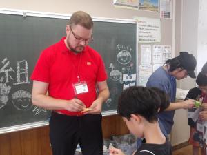 学校交流でこまの回し方を教わる様子